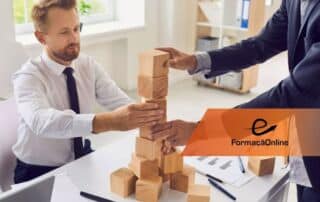 Two businessmen in a bright office stacking wooden blocks into a tower during a team-building exercise.