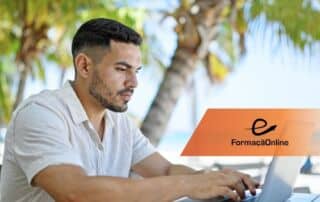 Man in a light shirt typing on a laptop at an outdoor table with palm trees in the background and an orange FormaçãoOnline banner nearby.