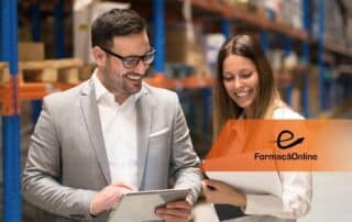 Two colleagues in a warehouse review a tablet together, smiling, with an orange FormaçãoOnline banner overlaying the image on the right.