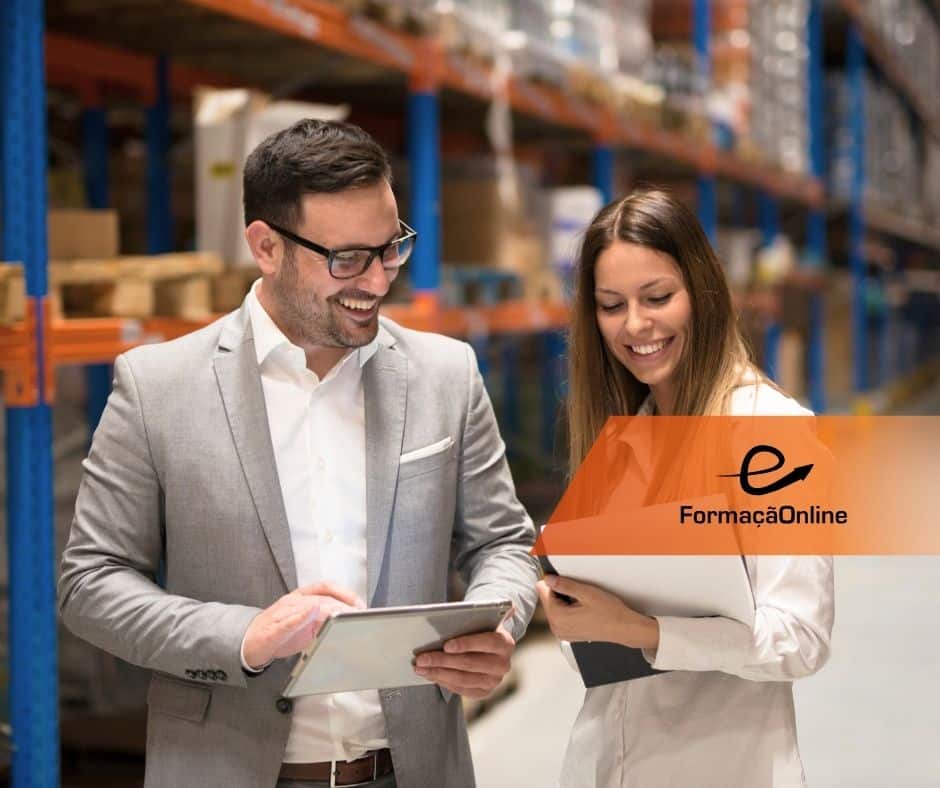 Two colleagues in a warehouse review a tablet together, smiling, with an orange FormaçãoOnline banner overlaying the image on the right.